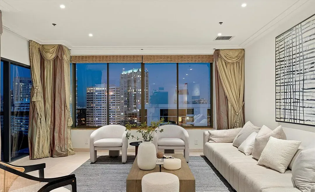 Living room at night with city lights through the windows