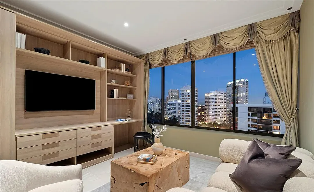 Family room with built-in oak shelving and city views