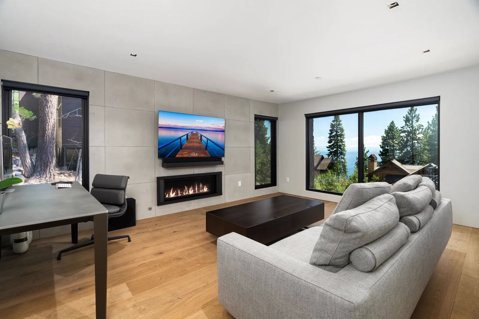 Family room with a linear fireplace, sectional sofa, and desk