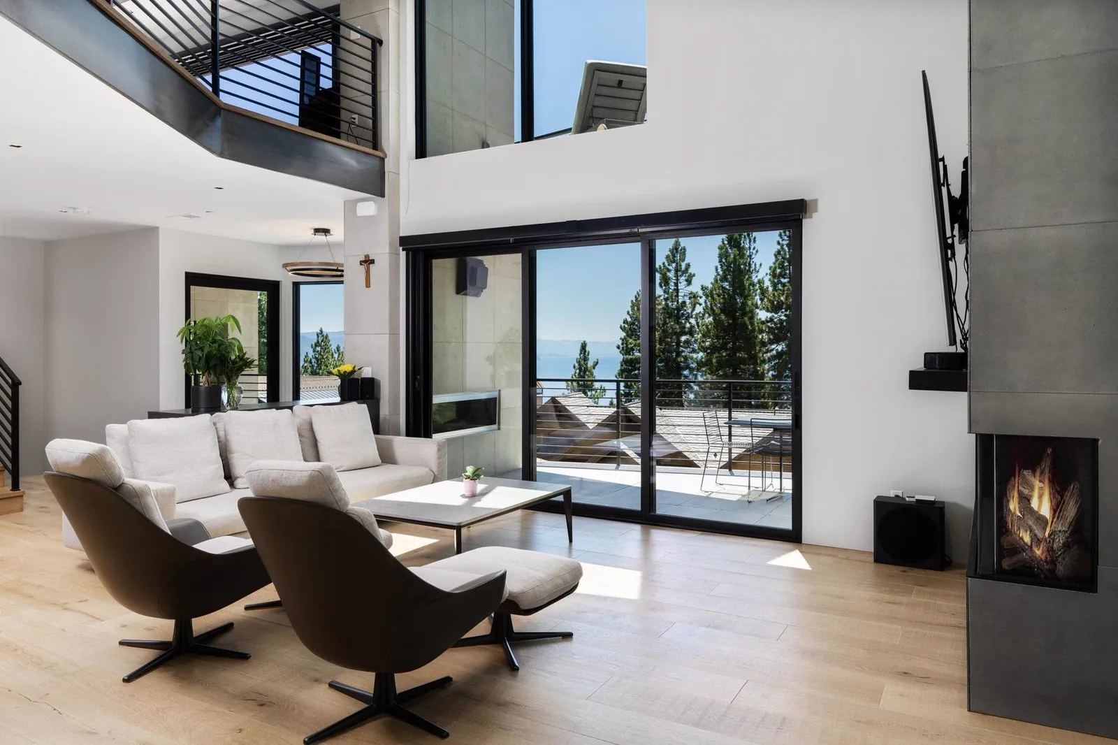 Living room with swivel chairs, a corner fireplace, and sliding doors to a deck