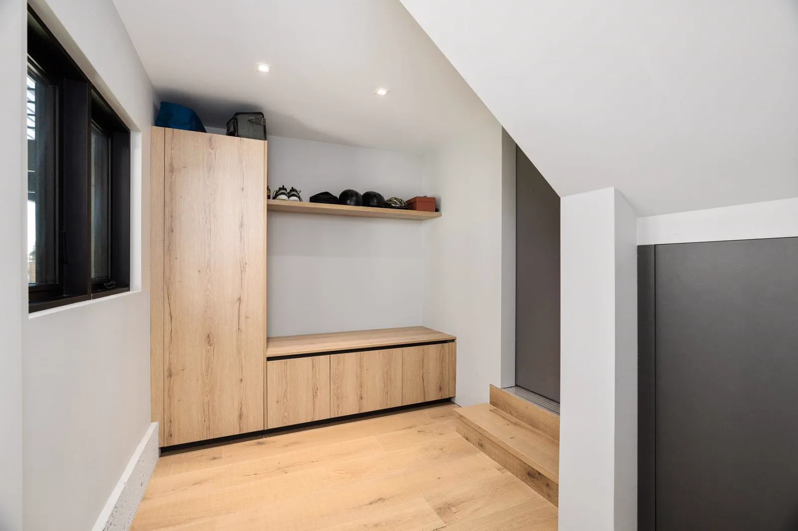 Mudroom with oak cabinetry and a bench