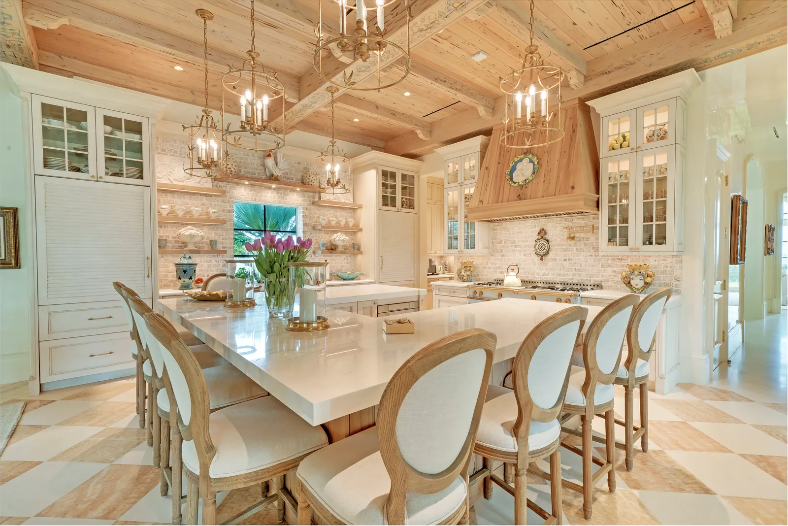 Kitchen island seating under a coffered ceiling with glass-front cabinets