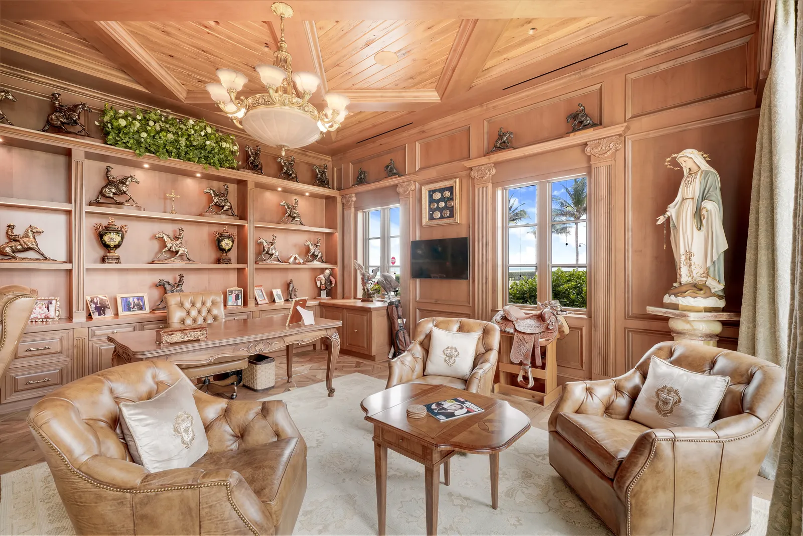Wood-paneled office with built-in shelves, leather chairs, and a coffered ceiling