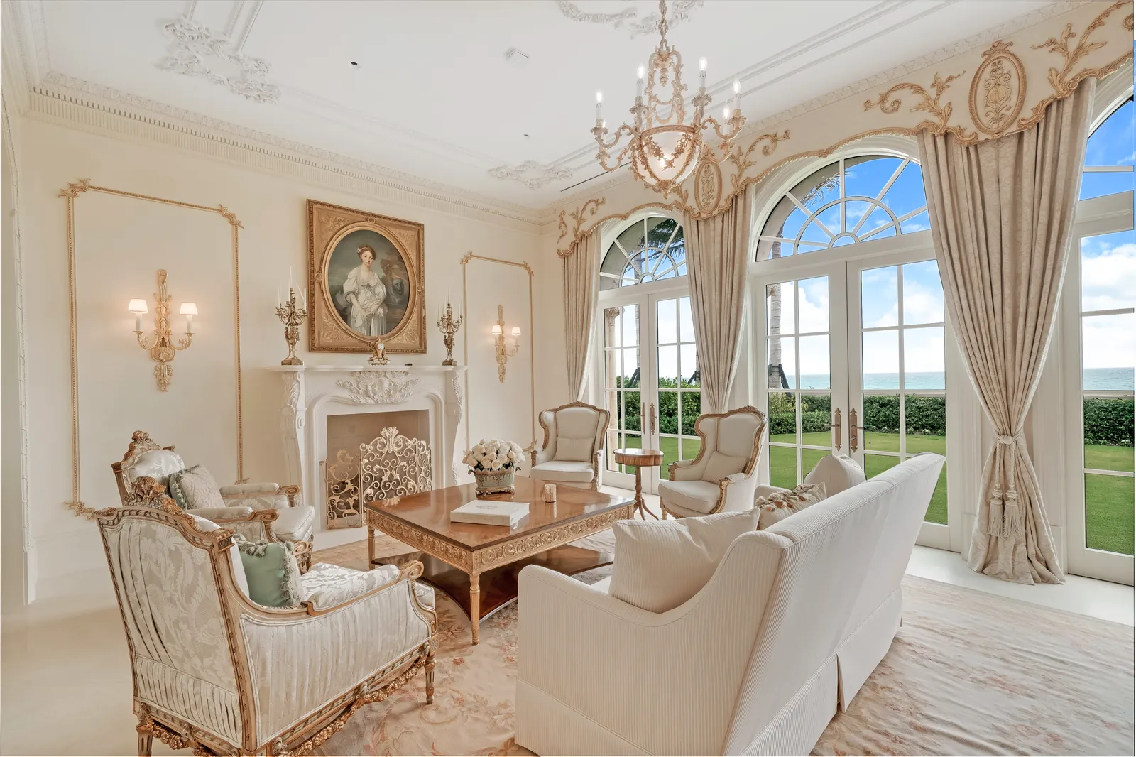 Living room with a marble fireplace, arched windows, and silk curtains
