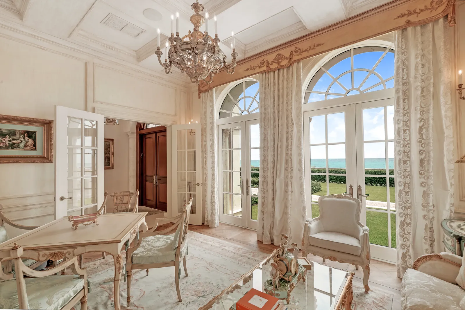 Sitting room with arched French doors facing the lawn and ocean