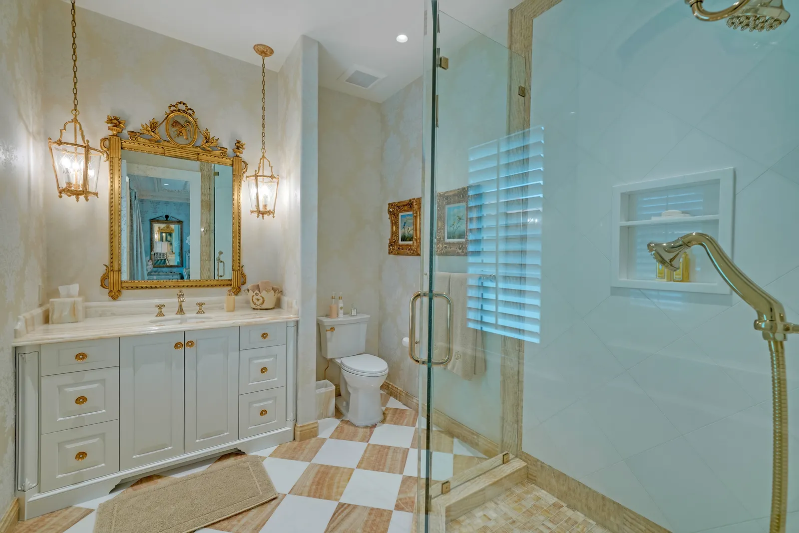 Bathroom with a painted vanity, gilded mirror, checkered floor, and glass shower