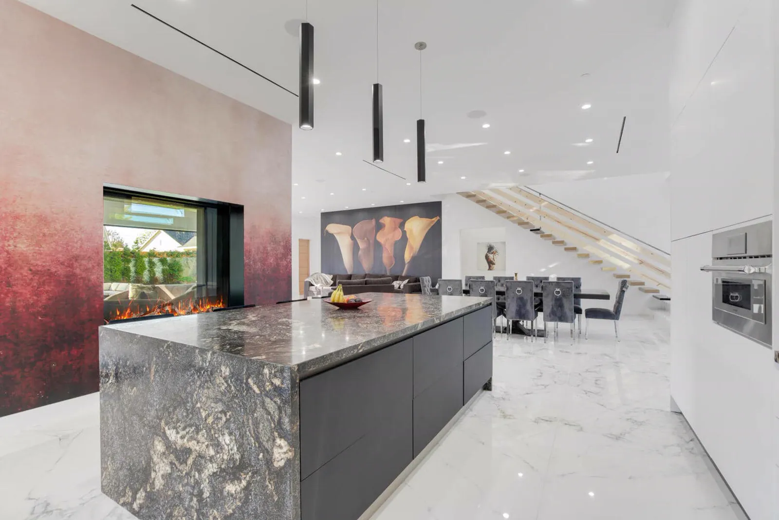 Dark granite kitchen island with the feature wall and dining area beyond