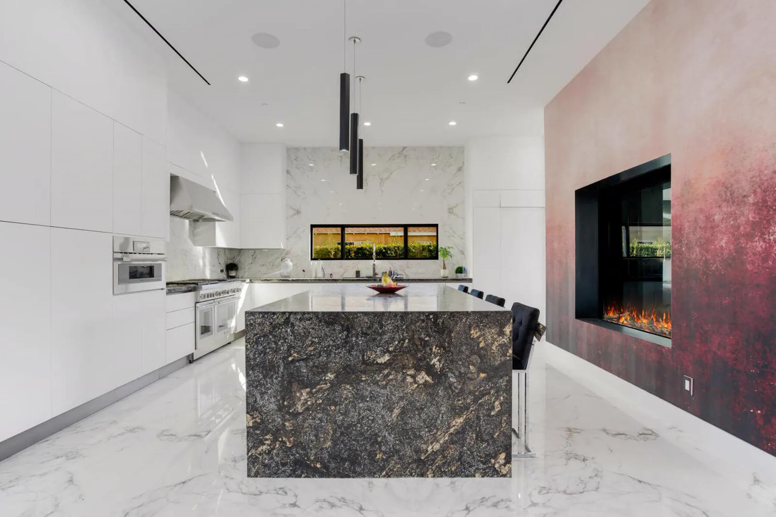 Granite island in front of a double-sided fireplace wall