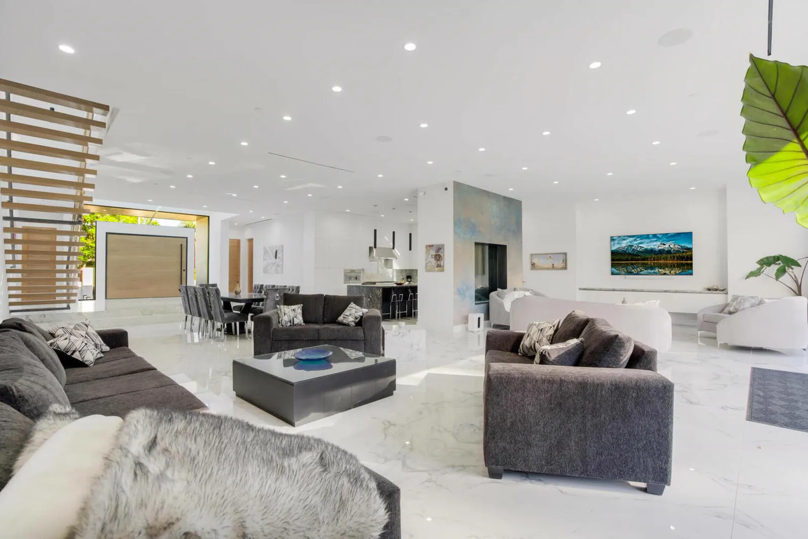 Living room with gray sofas, marble floors, and a slatted screen