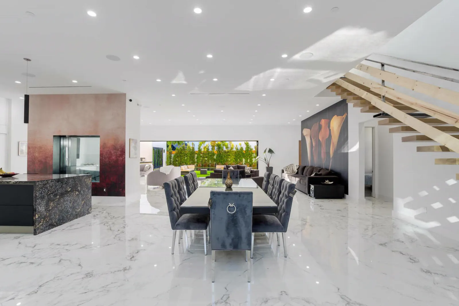 Dining room with a long table between the kitchen island and the floating stair