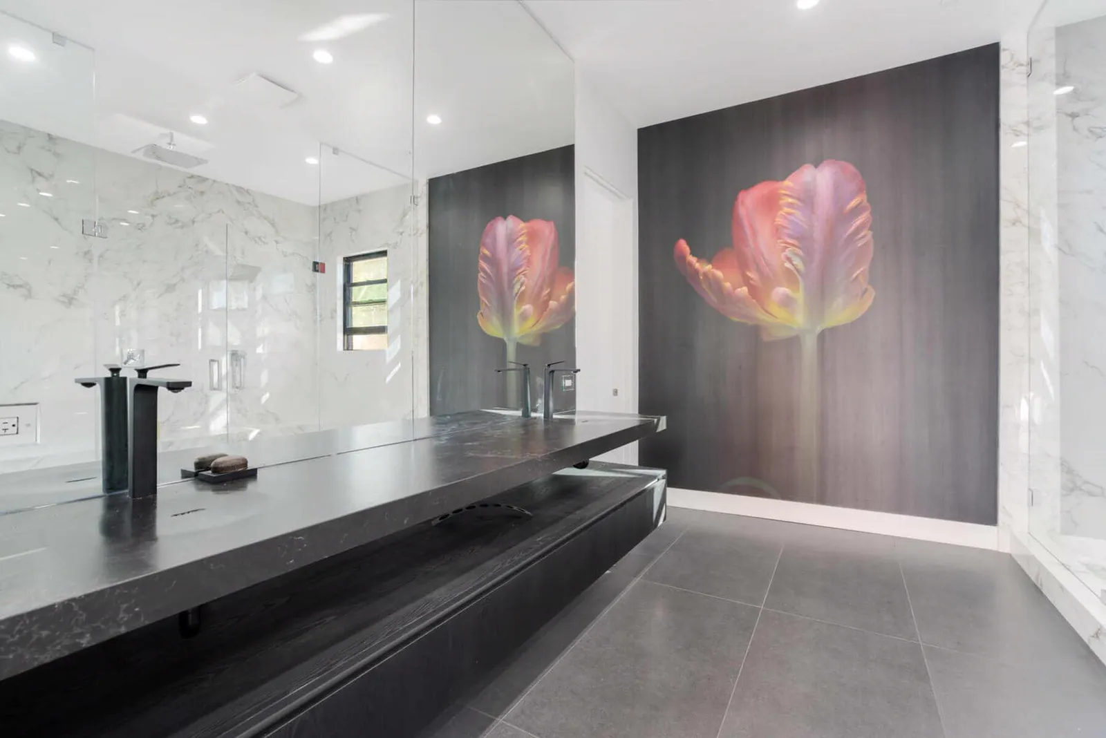 Dark stone counter beneath a large floral artwork