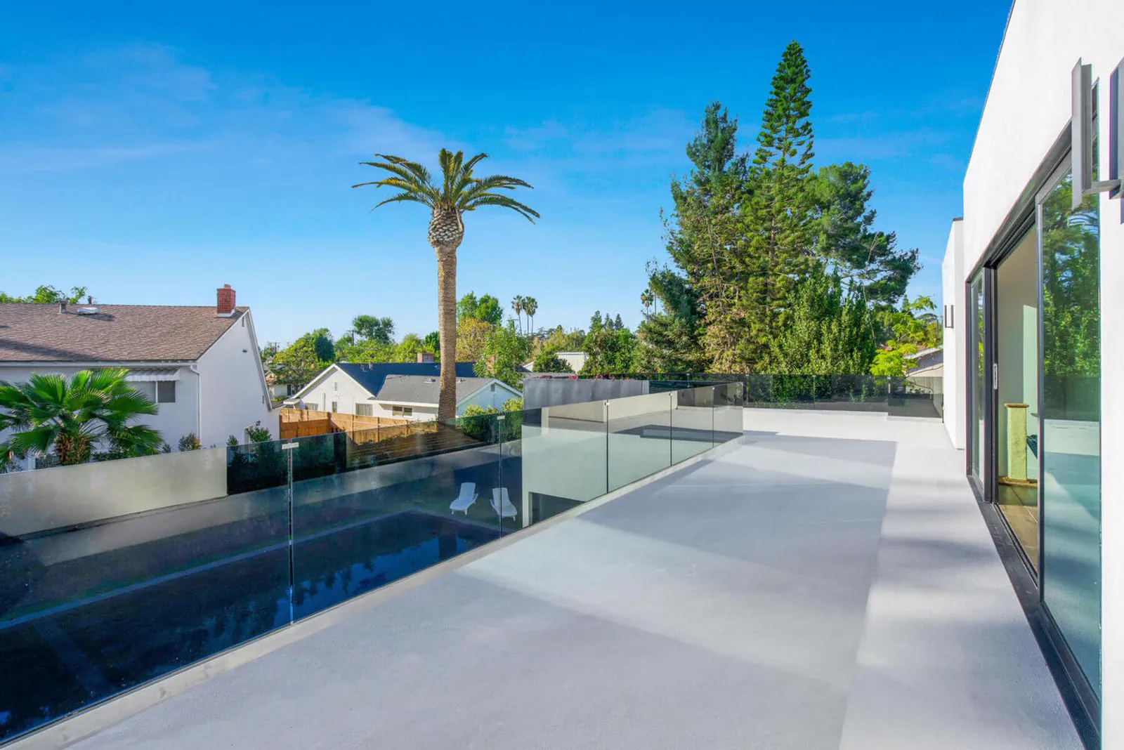 Terrace along sliding glass walls with the pool below