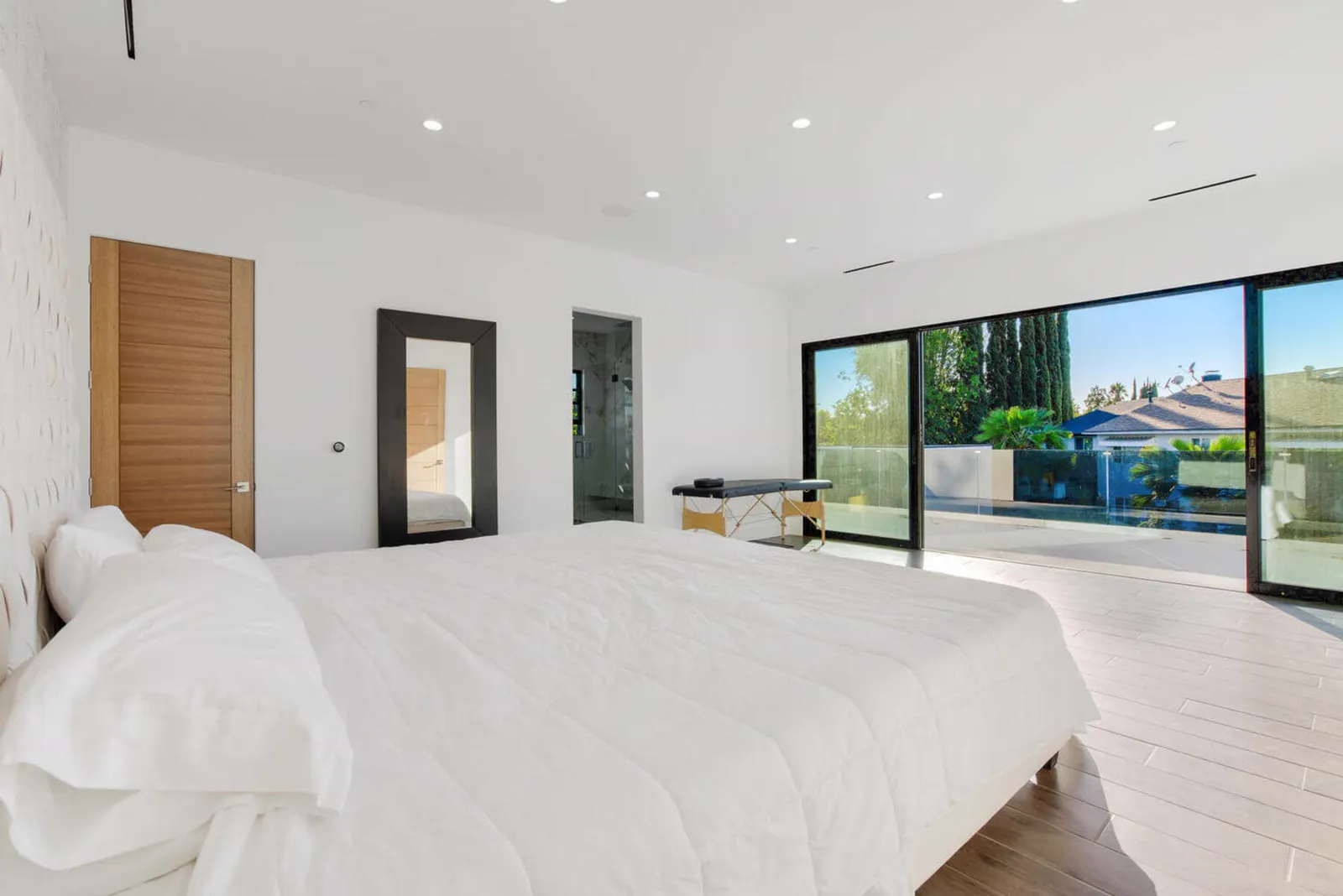 Bedroom with wood doors and sliding glass doors to the yard