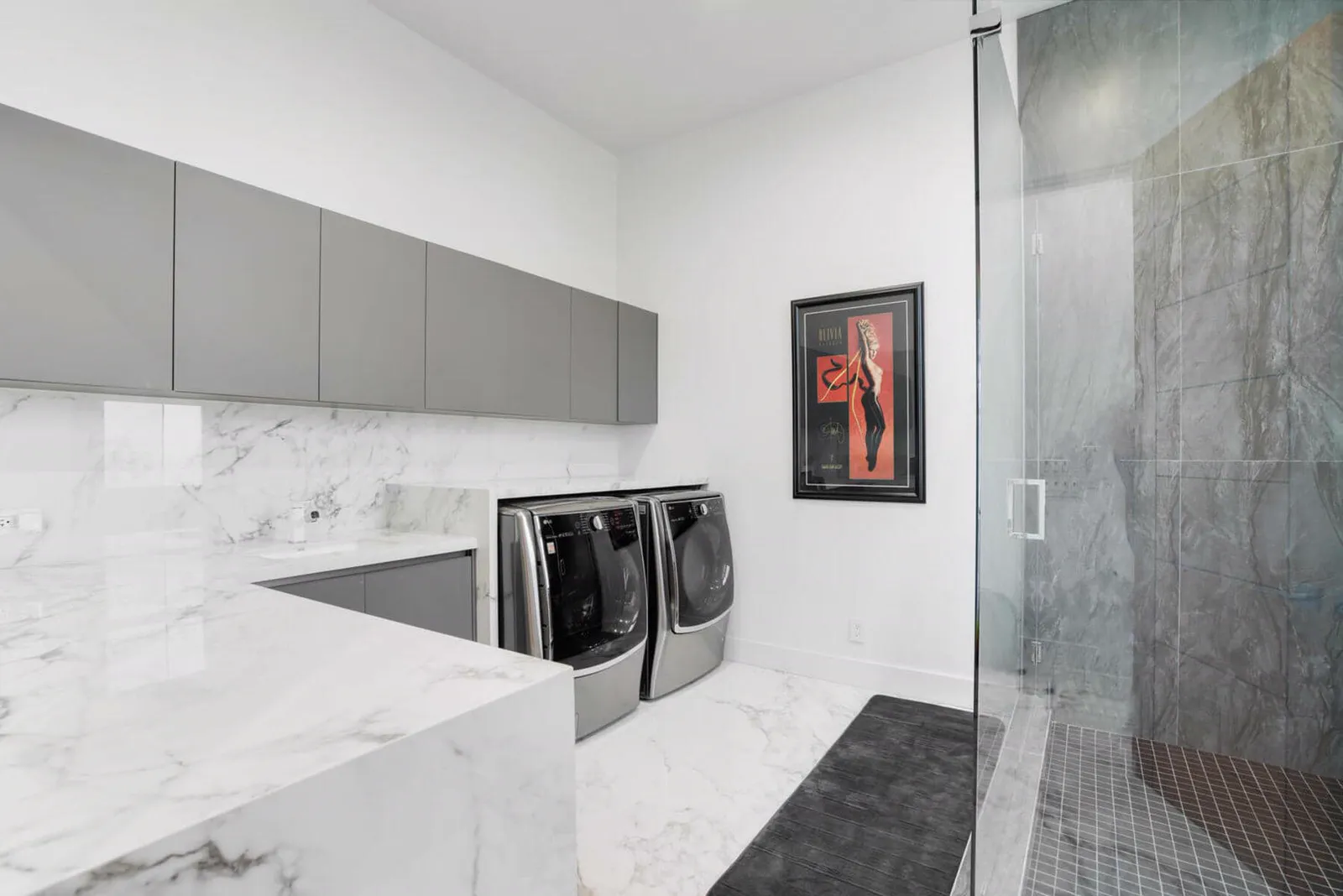 Laundry room with marble counters and gray upper cabinets