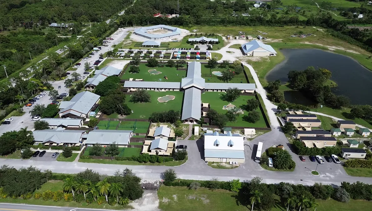 Aerial view of the rescue campus with buildings, play yards, and a lake