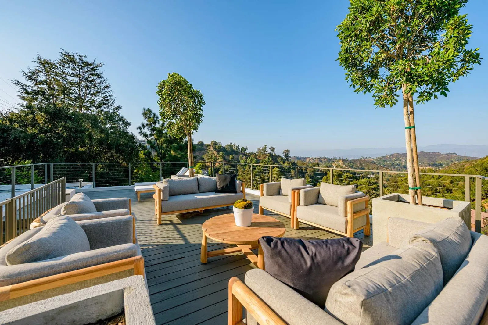 Roof deck seating with teak sofas at sunset