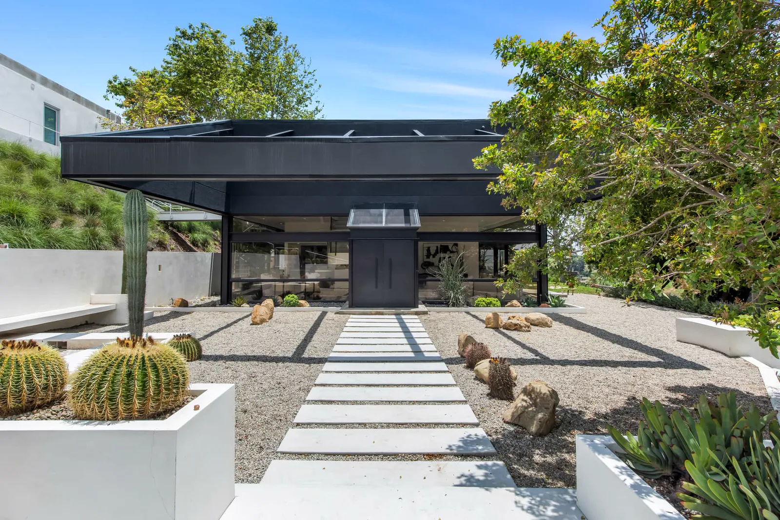 Walkway through a desert garden to the glass and steel house