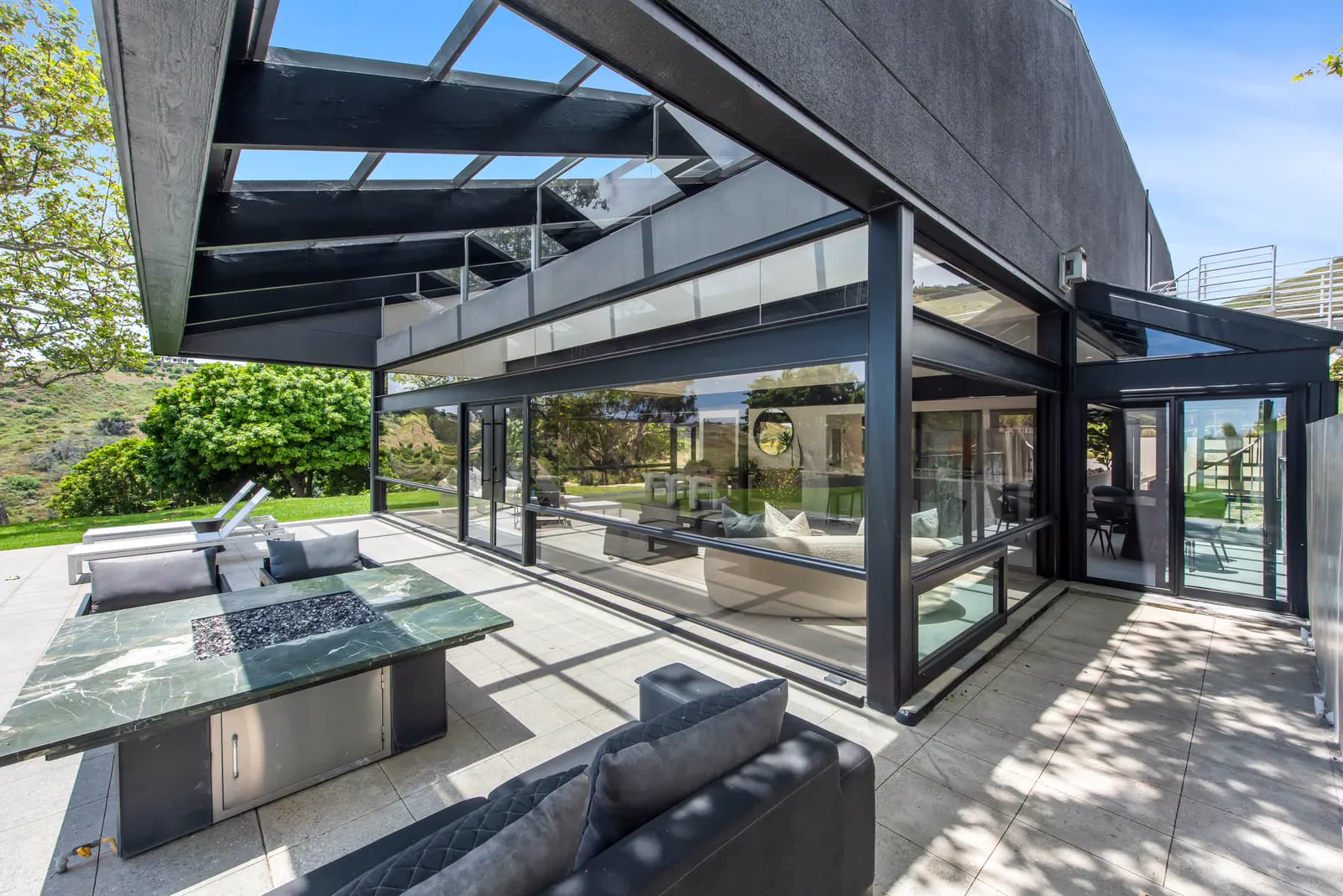 Covered terrace with an outdoor table beside the glass house