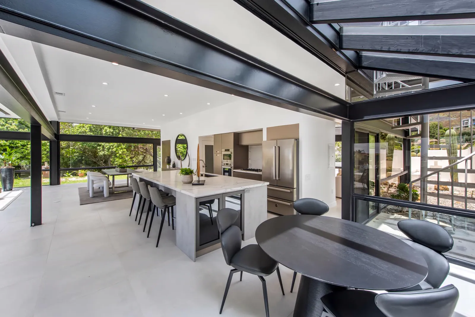 Kitchen and breakfast table under a steel-framed glass roof