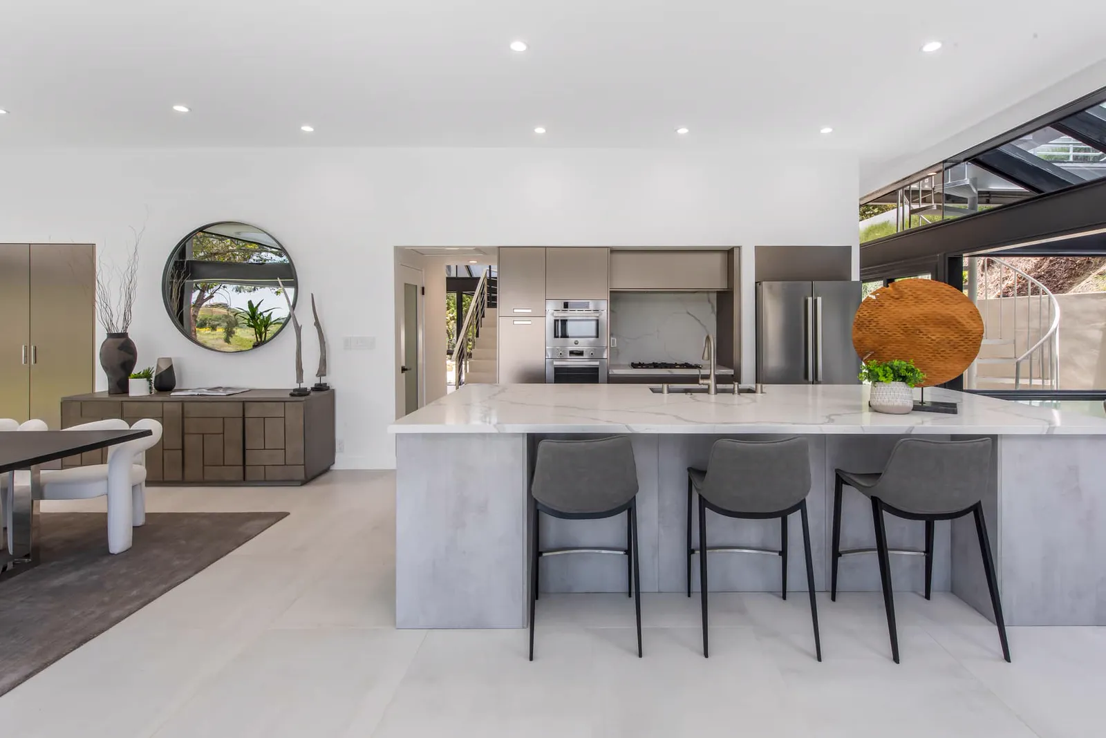 Kitchen island with stools and a built-in appliance wall
