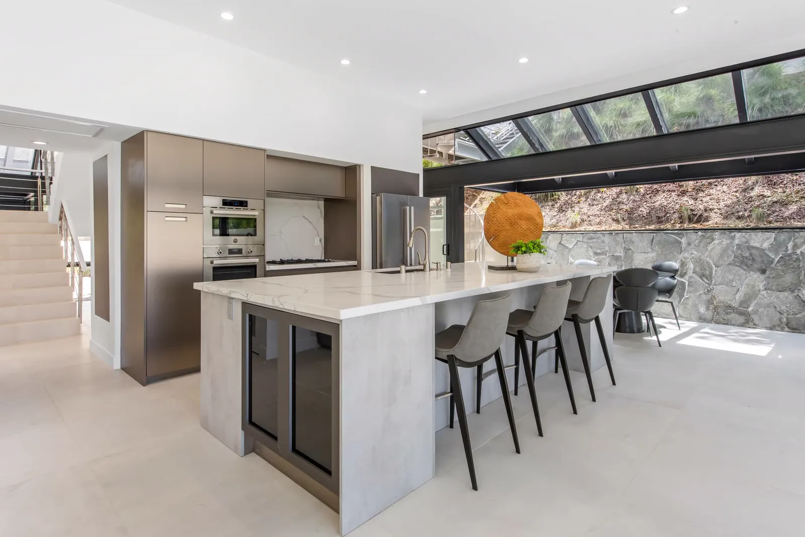 Kitchen island with a waterfall stone counter and stools