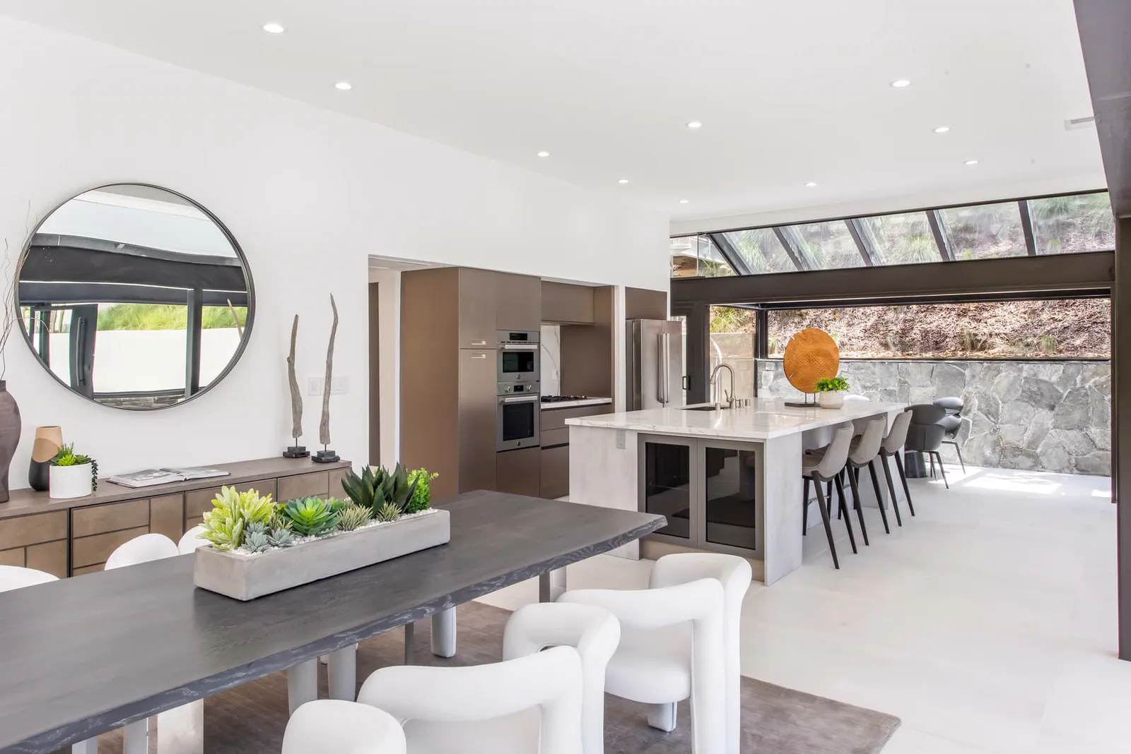 Dining table with sculptural chairs and the kitchen beyond