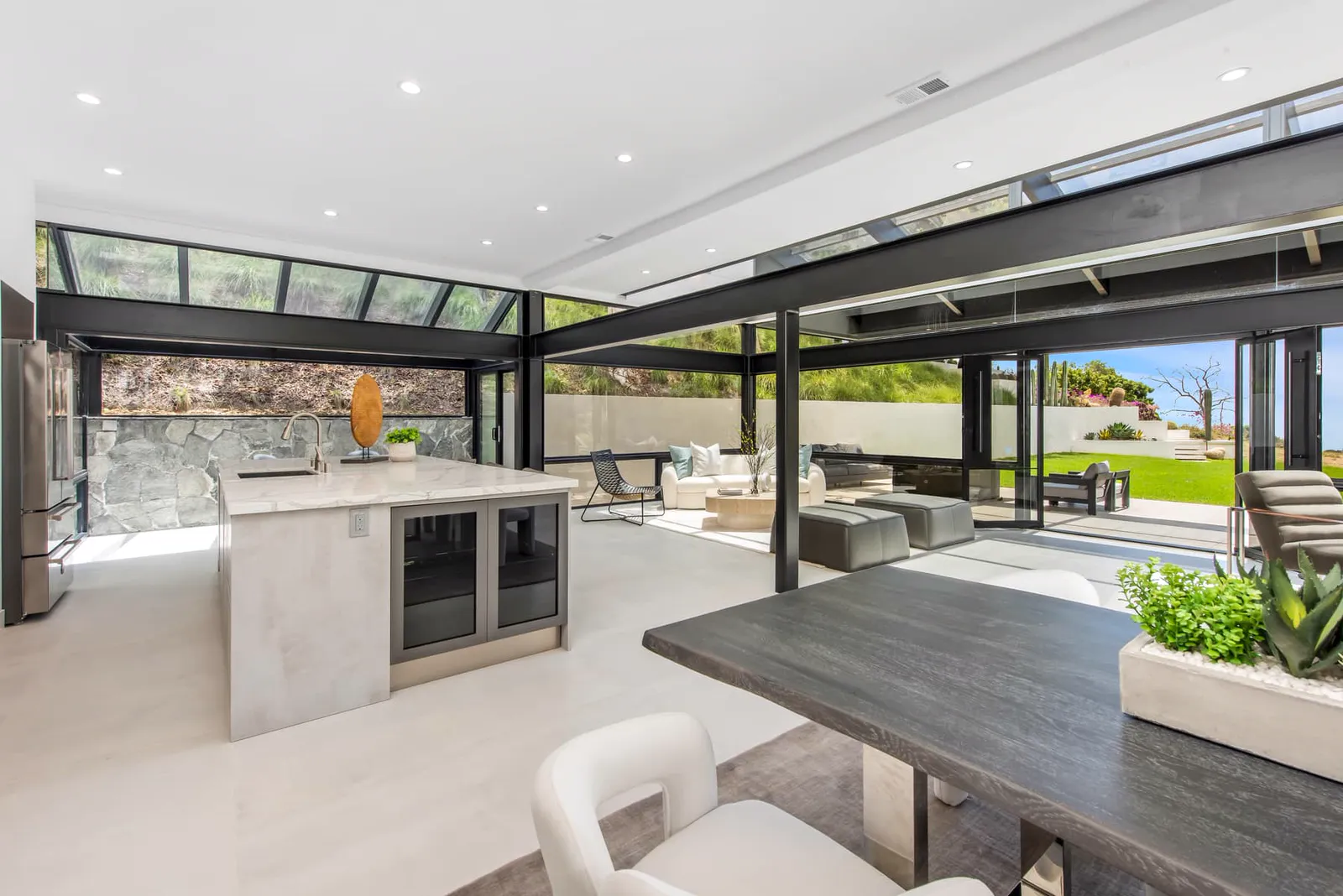 Dining table and kitchen island with a stone wall beyond