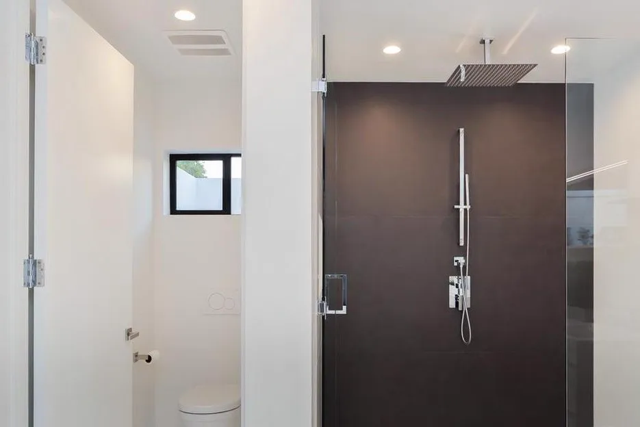 Bathroom with a dark tile walk-in shower and frameless glass