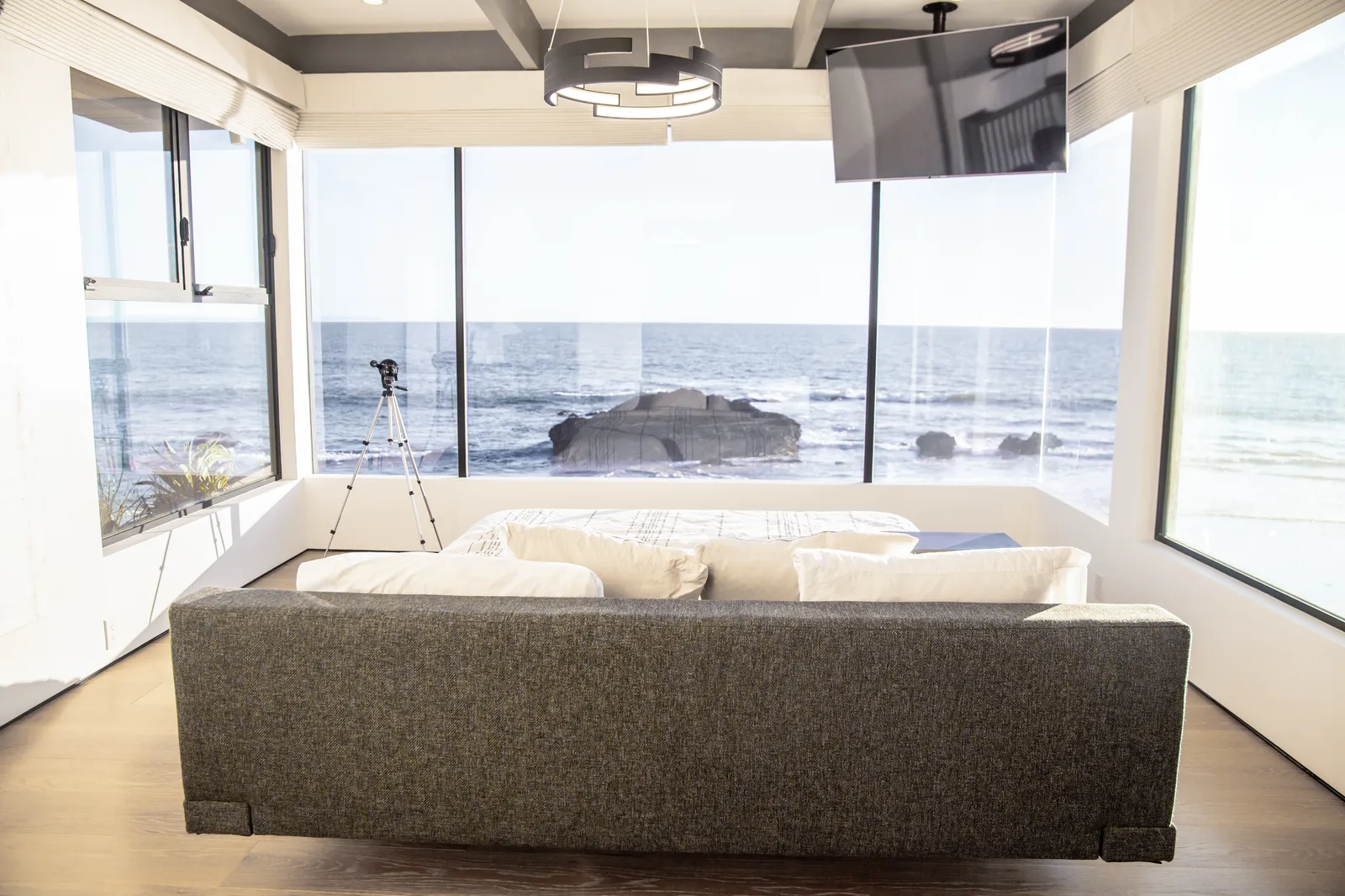 Family room with a sofa facing floor-to-ceiling windows and the ocean