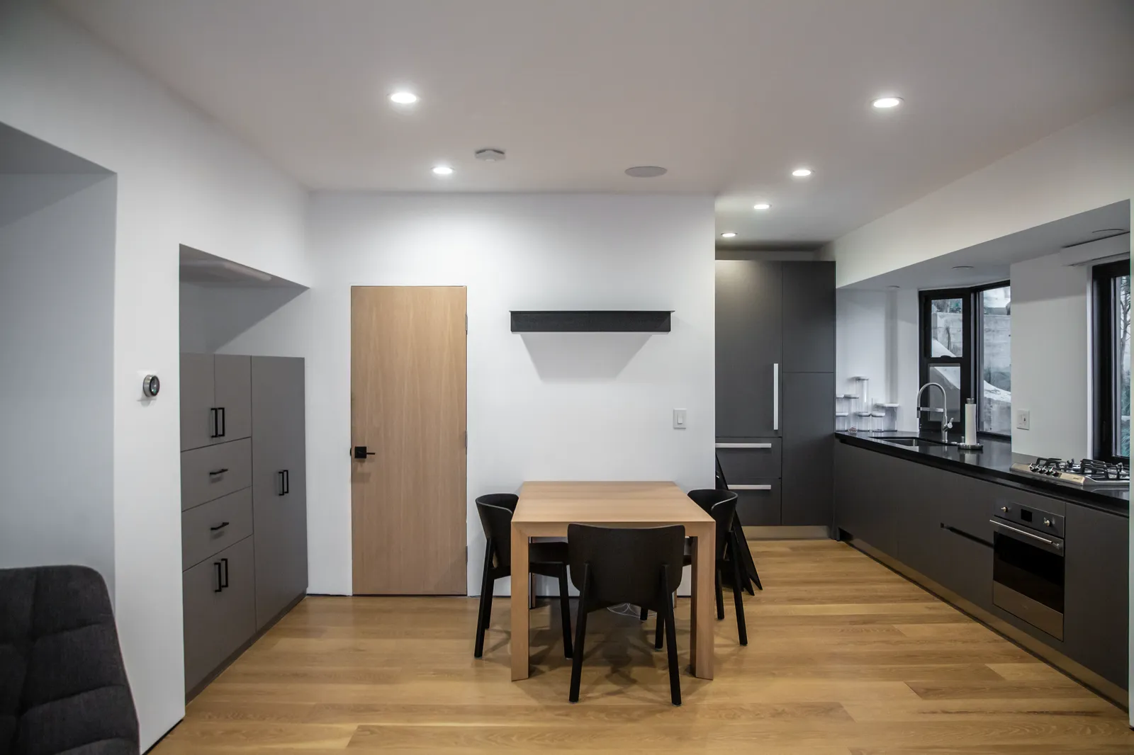 Kitchenette and dining table with dark cabinetry
