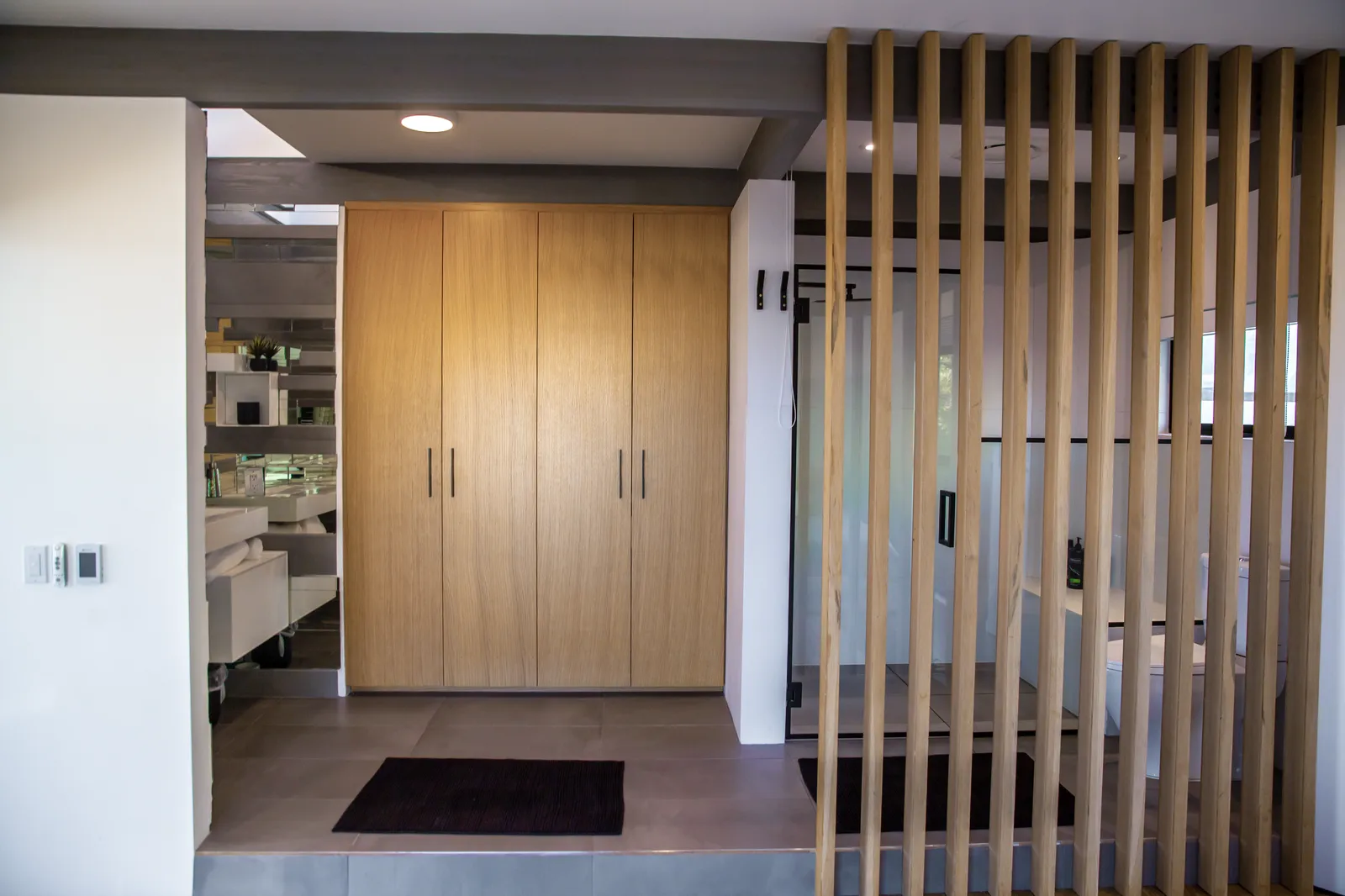 Entry with an oak wardrobe and a vertical wood slat screen