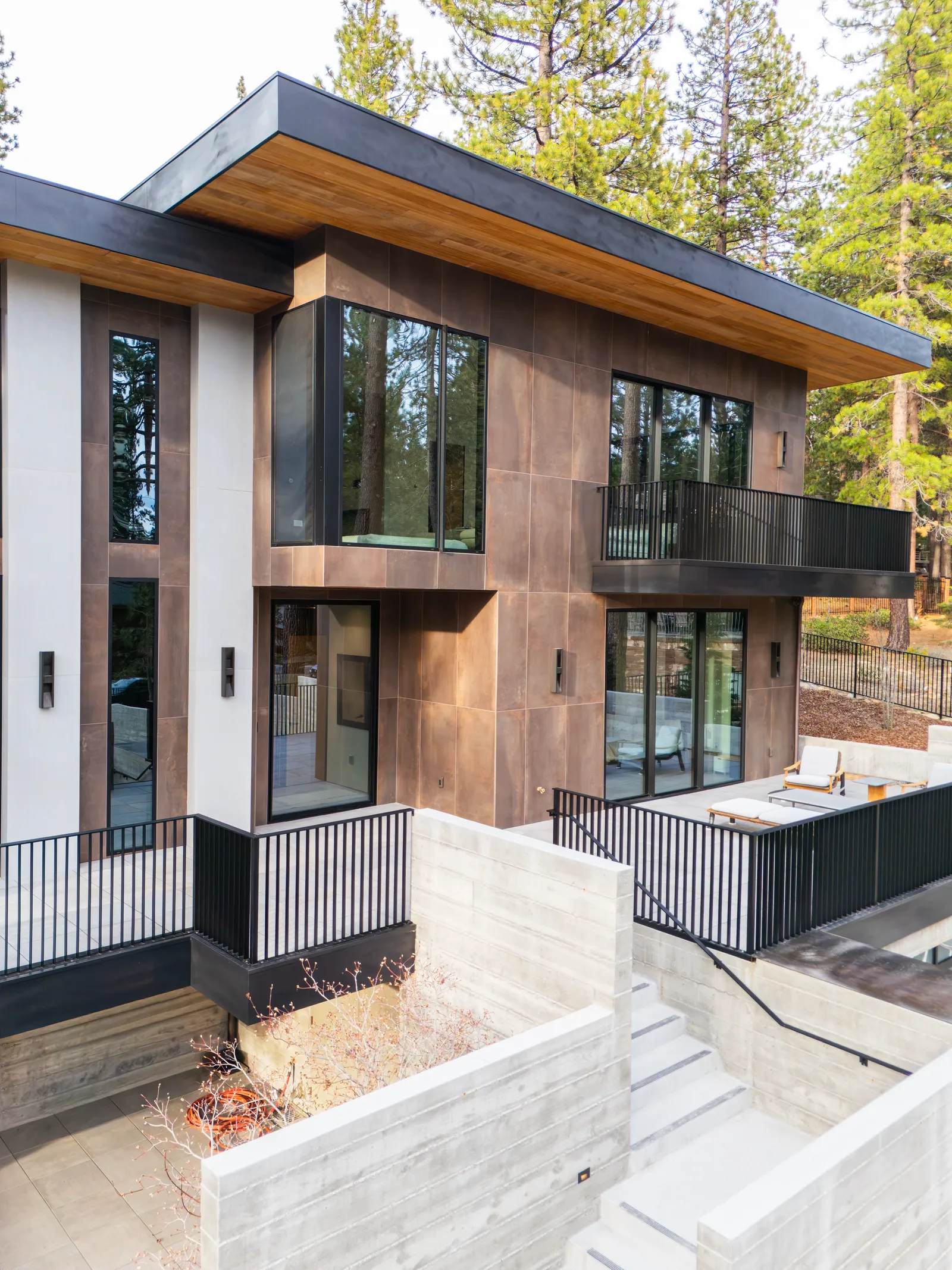 Exterior with stacked balconies, dark window frames, and concrete retaining walls