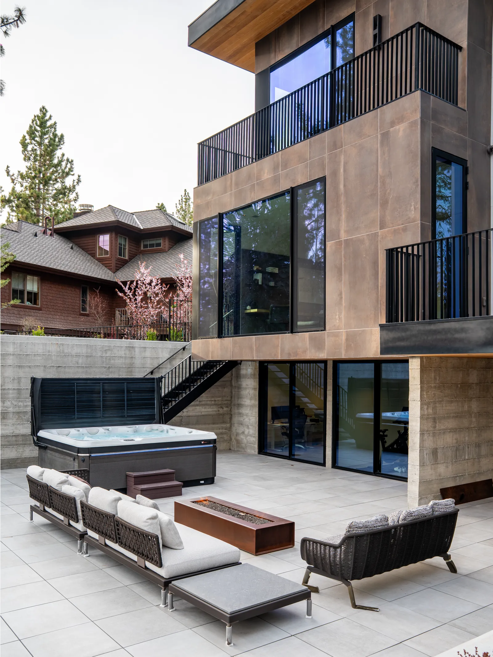 Lower terrace with outdoor seating and a hot tub below the house