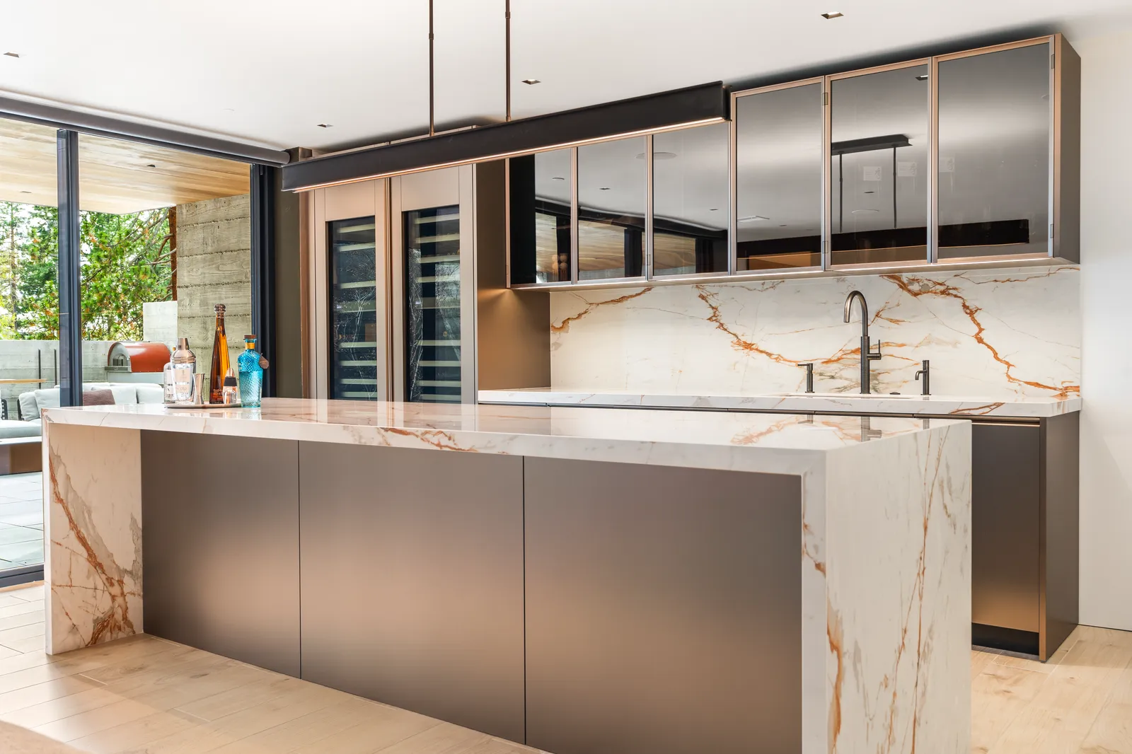Bar counter in gold-veined stone with dark cabinetry