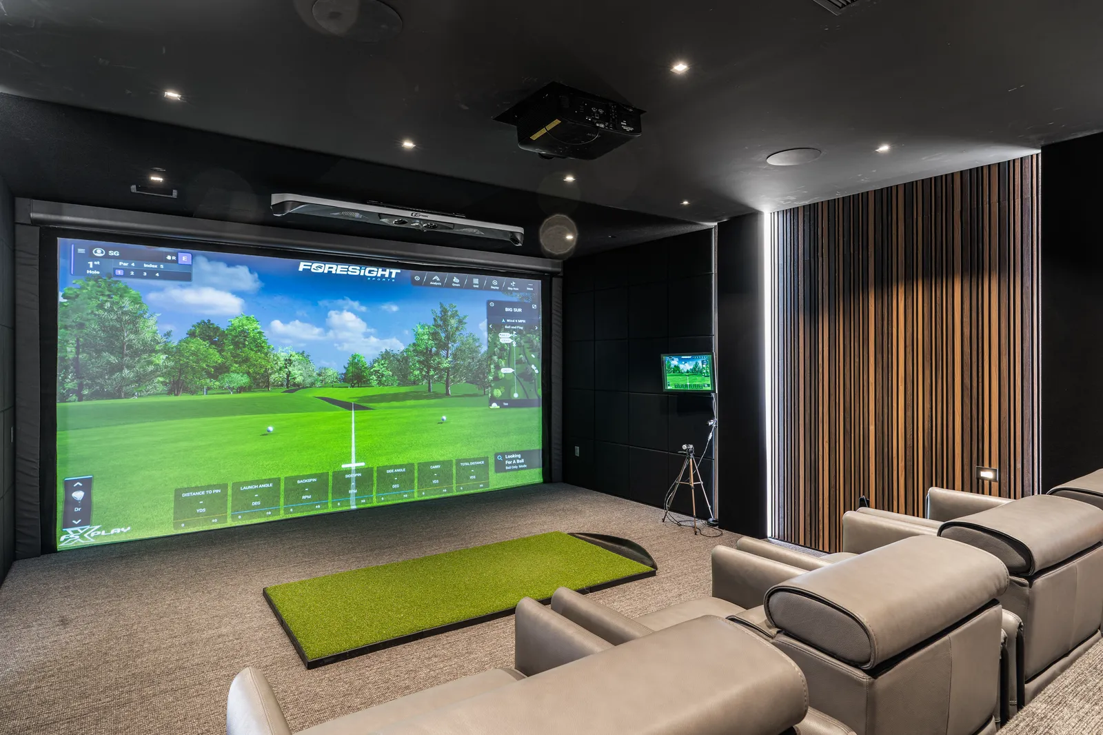 Golf simulator room with lounge seating and wood slat walls