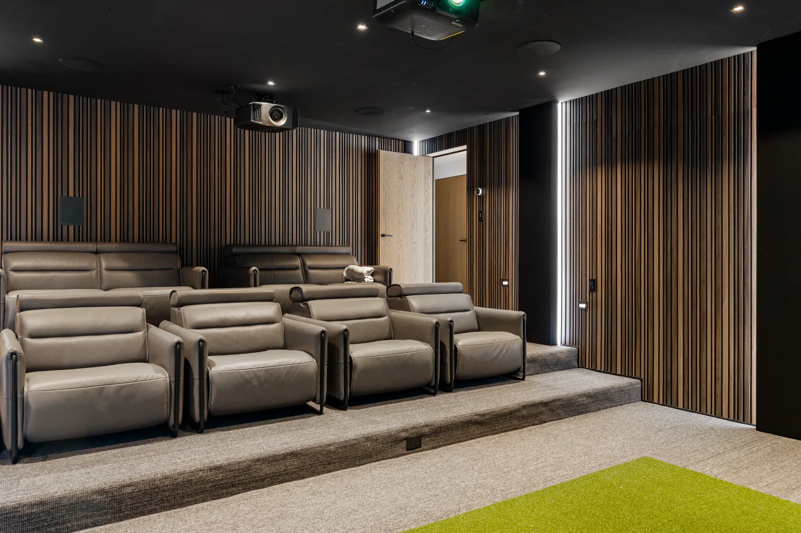 Home theater with tiered reclining seats and wood slat walls