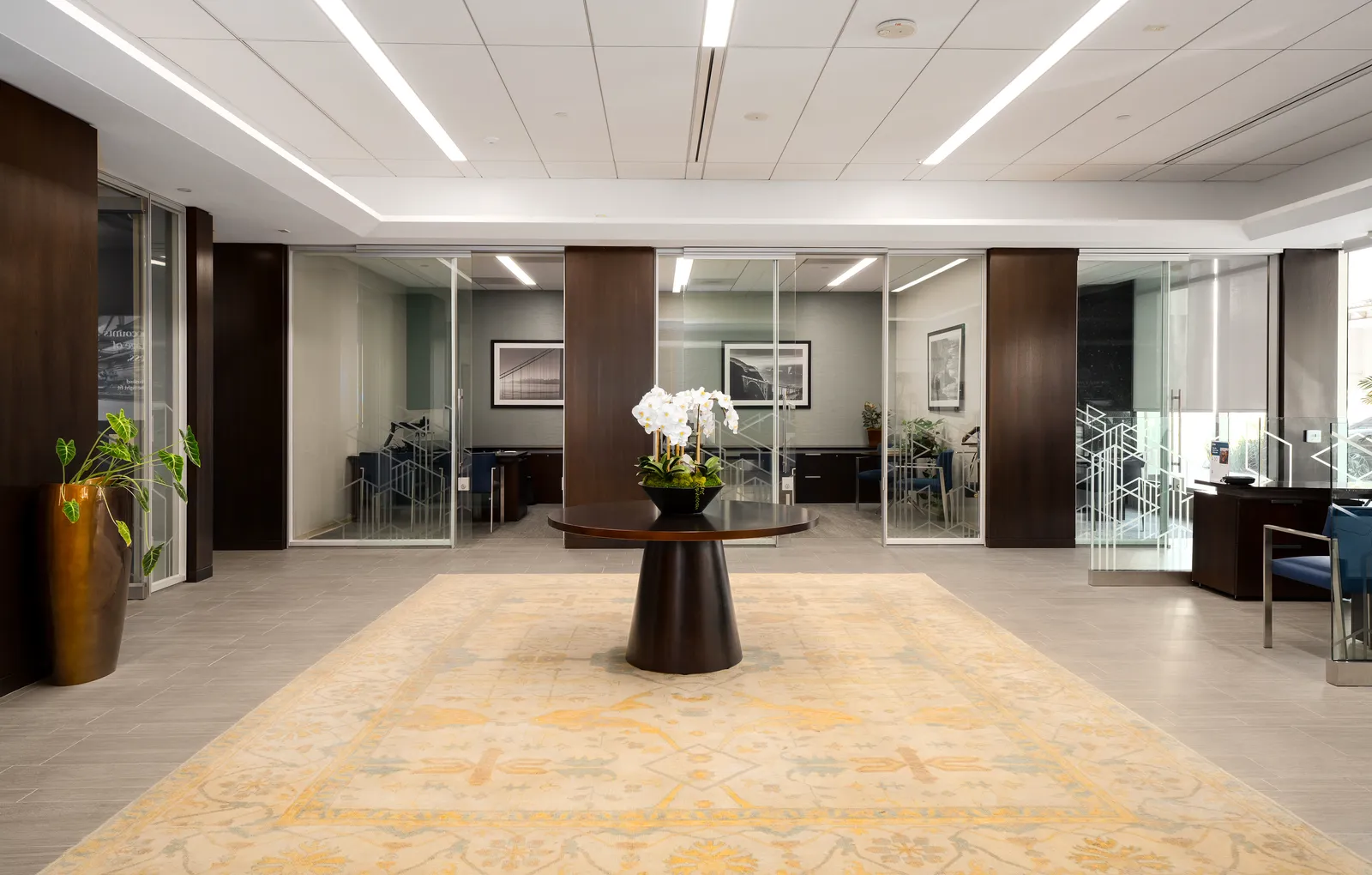 Open lobby with walnut-clad columns and glass offices