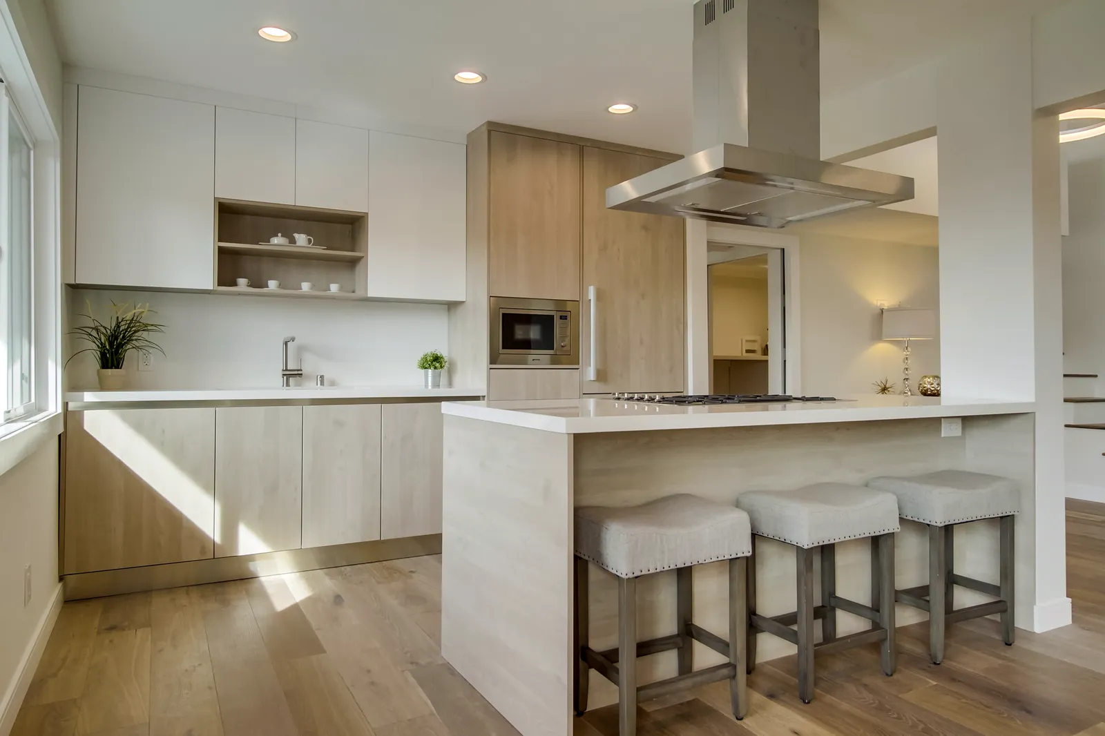 Kitchen island with stools and a white quartz waterfall edge