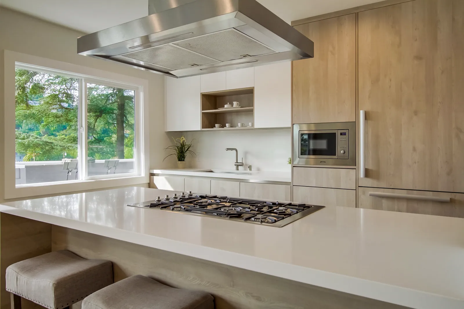 Kitchen island with bar stools beside a window