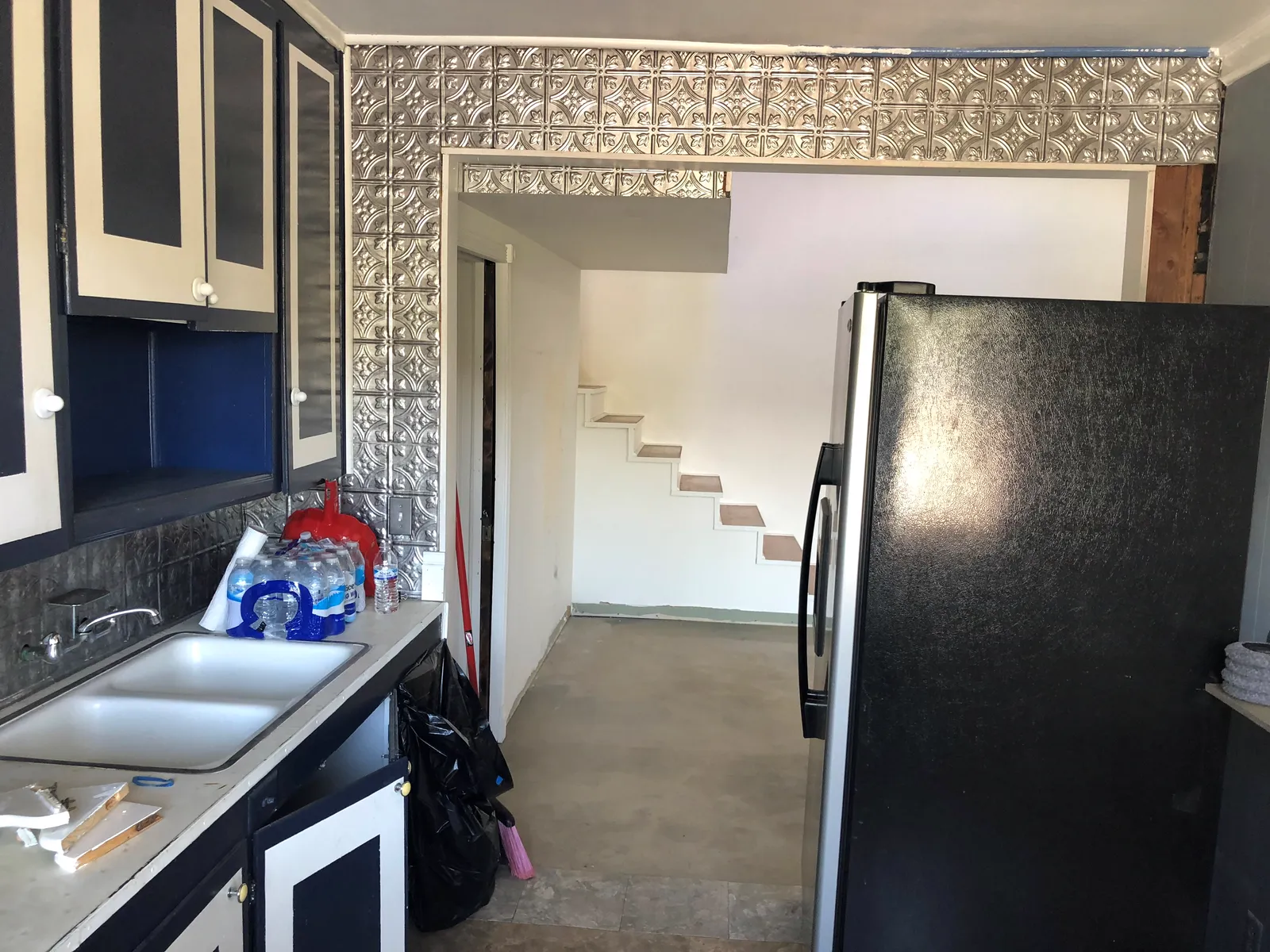 Before the renovation: the original kitchen with dark cabinets and a dated tile backsplash
